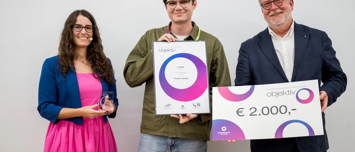 Florian Sulzer (Mi.) mit seiner Urkunde, daneben Eva Kelety, Bundesinnungsmeisterin der Berufsfotografie