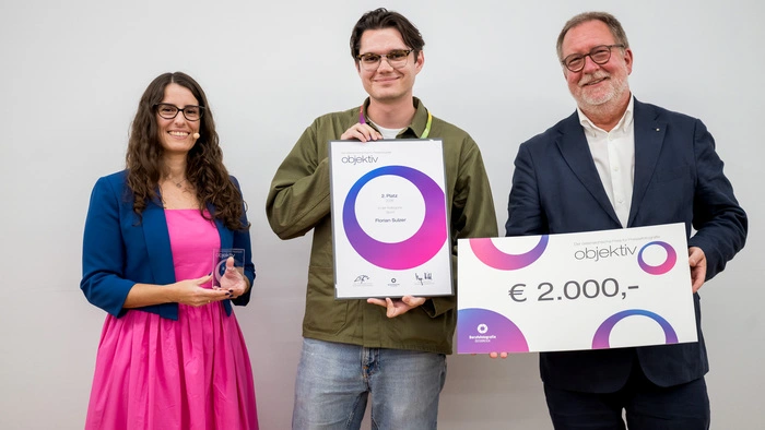 Florian Sulzer (Mi.) mit seiner Urkunde, daneben Eva Kelety, Bundesinnungsmeisterin der Berufsfotografie