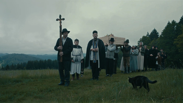 Das Bild zeigt eine Filmszene aus der aktuellen Sagenjäger-Folge. Darauf zu sehen ist ein Trauermarsch mit Sarg, Kreuzträger, Pfarrer und Bevölkerung.