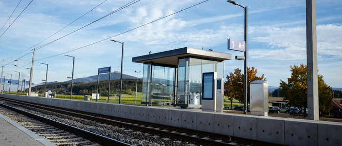 Das Bild zeigt einen Bahnsteig mit Wartekoje und Infotafel