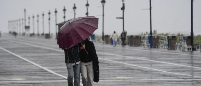 A couple fights against strong winds and rain on the boardwalk in Ocean City, New Jersey, on September 26, 2026. Heavy rain and strong winds battered the northeastern United States as an unusually powerful autumn storm intensified, forcing the cancelation of hundreds of flights and leaving tens of thousands of people without power. New York, Boston and Philadelphia were all in the firing line of the "Nor'easter" -- so labeled for its northeasterly winds -- as authorities warned of potential major flooding and road closures. (Photo by Matthew HATCHER / AFP)