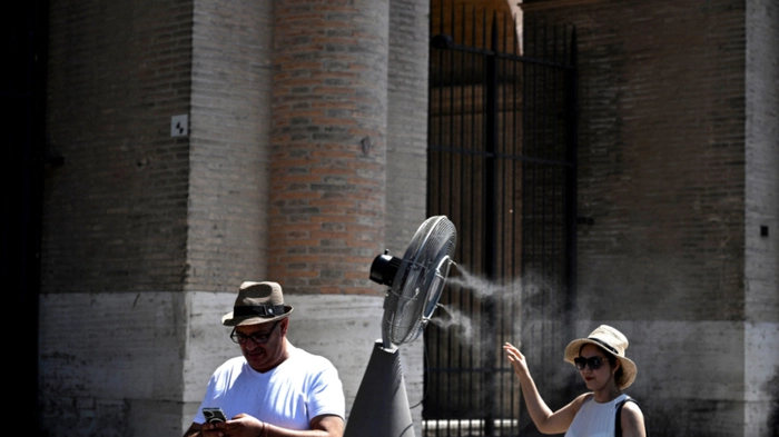 Passanten bei vor dem Kollosseum in Rom aufgestelltem Ventilator