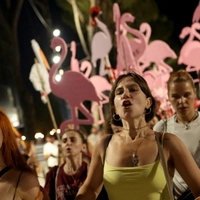 Protesters hold placards shaped as flamingos during a demonstration in front of the Albanian Prime Minister's Office in Tirana, on August 14, 2026, against the construction of a luxury resort near a protected natural area on Albania's southern coast. Preliminary work on a vast hotel project linked to the Trump family has already caused irreparable damage to a once pristine stretch of Albania's coast, scientists and activists say. (Photo by Adnan Beci / AFP)
