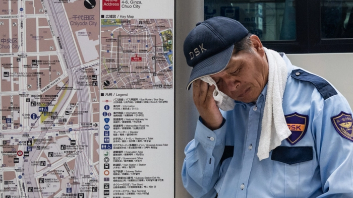A security guard wipes his face on a hot day in Tokyo on July 24, 2026. (Photo by Andrew CABALLERO-REYNOLDS / AFP)