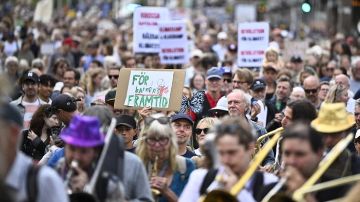 Protesters take part in a climate demonstration organized by the Swedish Society for Nature Conservation together with Rebel Moms, Rebel Dads and Researchers Desk in central Stockholm, Sweden, on August 23, 2026. Since taking power in 2022, Prime Minister Ulf Kristersson's right-wing government, backed by the populist Sweden Democrats party, has cut petrol taxes and reduced requirements for petrol suppliers to add low-carbon alternatives to their mix. (Photo by Christine Olsson/TT / TT News Agency / AFP) / Sweden OUT