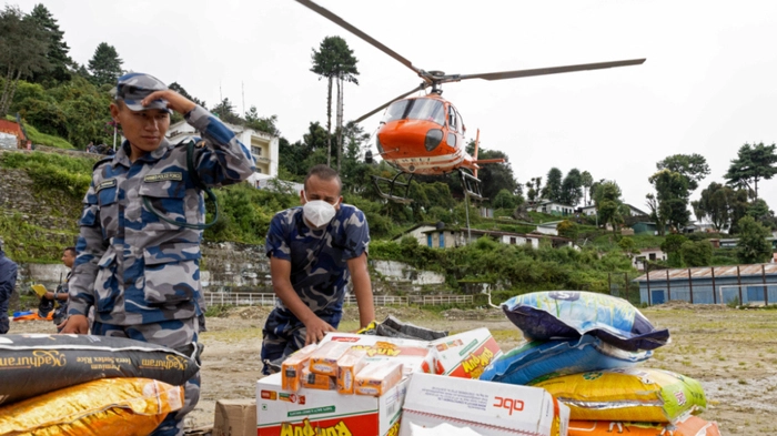 Nepal Armed Police Force (APF) personnel load relief supplies for flood victims onto a helicopter at Dhunche Bazaar in Nepal's Rasuwa district on August 31, 2026. At least 4,471 people were listed as missing on August 31, with a further 955 confirmed dead, after the flash floods and landslides that hit the Nepal border. (Photo by PRABIN RANABHAT / AFP)