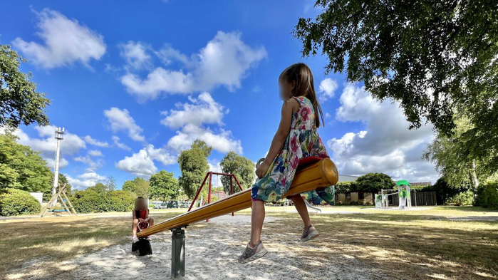 Zwei Mädchen wippen auf einer Wippe in einem Park