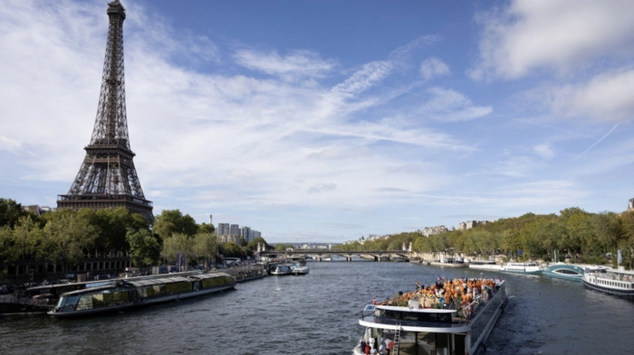 Members of the Bochasanwasi Akshar Purushottam Swaminarayan Sanstha (BAPS) Hindu community pass the Eiffel tower as they take part in a ceremonial river parade on the river Seine in Paris on September 3, 2026, as part of a series of religious celebrations and rituals. (Photo by Kenzo TRIBOUILLARD / AFP)