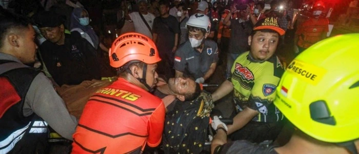 TOPSHOT - Rescue teams evacuate a victim of the Virgo Transport 8 passenger ferry, which capsized while carrying 243 people on its route to Banjarmasin from Surabaya, to a hospital in Banjarmasin, South Kalimantan on September 13, 2026. Rescuers in Indonesia said at least six people were killed and 130 others were missing on September 13 after a ferry sailing between the islands of Java and Borneo was hit by bad weather and capsized. (Photo by INFUZ / AFP)