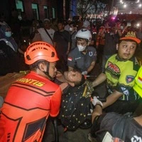 TOPSHOT - Rescue teams evacuate a victim of the Virgo Transport 8 passenger ferry, which capsized while carrying 243 people on its route to Banjarmasin from Surabaya, to a hospital in Banjarmasin, South Kalimantan on September 13, 2026. Rescuers in Indonesia said at least six people were killed and 130 others were missing on September 13 after a ferry sailing between the islands of Java and Borneo was hit by bad weather and capsized. (Photo by INFUZ / AFP)