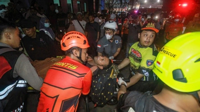 TOPSHOT - Rescue teams evacuate a victim of the Virgo Transport 8 passenger ferry, which capsized while carrying 243 people on its route to Banjarmasin from Surabaya, to a hospital in Banjarmasin, South Kalimantan on September 13, 2026. Rescuers in Indonesia said at least six people were killed and 130 others were missing on September 13 after a ferry sailing between the islands of Java and Borneo was hit by bad weather and capsized. (Photo by INFUZ / AFP)