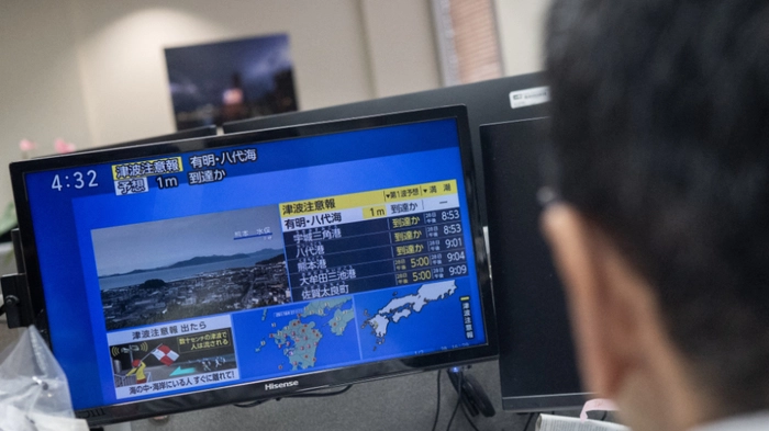 Reporters watch the news showing a large quake and possible one meter tsunami wave in Southern Japan, from an office in Tokyo on July 28, 2026. A strong 7.1-magnitude earthquake hit southern Japan, the Japan Meteorological Agency said, issuing a tsunami alert. The tremor also measured at the highest possible level seven on Japan's own Shindo scale of shaking, the agency said. (Photo by Andrew CABALLERO-REYNOLDS / AFP)