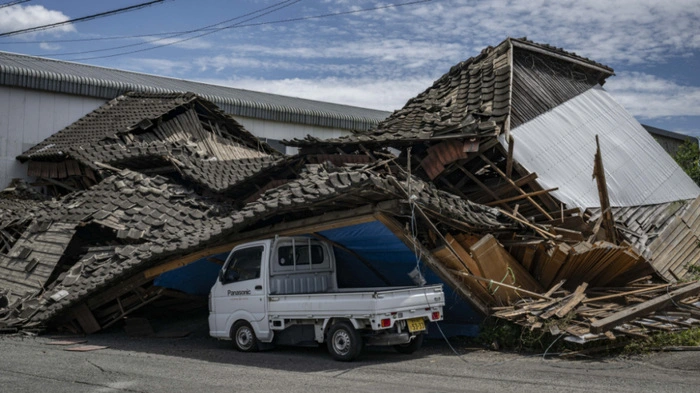 A house is seen collapsed onto a car in Yatsushiro, Kumamoto prefecture on July 29, 2026, after an earthquake struck southwestern Japan the previous day. (Photo by Yuichi YAMAZAKI / AFP)