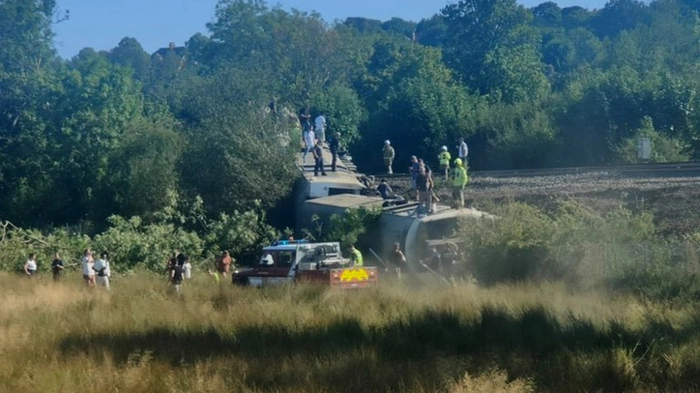 Menschen standen auf den umgekippten Waggons