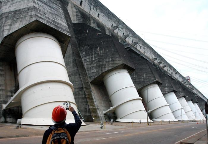 Tourist fotografiert Staumauer des Wasserkraftwerks Itaipu in Foz do Iguacu in Brasilien. (Symbolfoto)