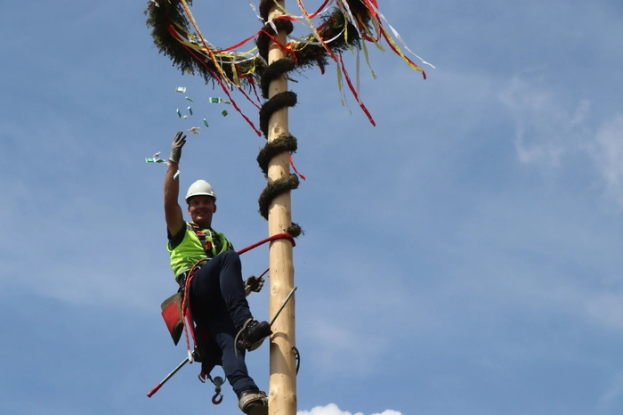 Ein Kelag-Mitarbeiter verteilte vom Maibaum Süßigkeiten für die Kinder.