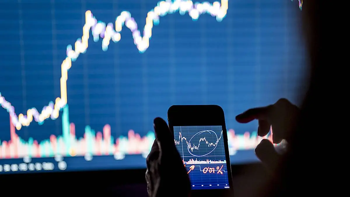 Businesswoman investing in stock market through smart phone in office model released Symbolfoto property released DLTSF02232 