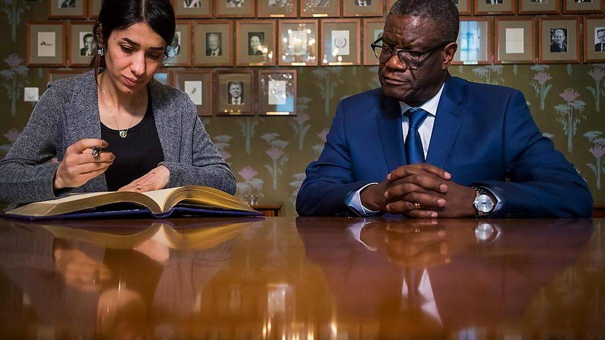 Nadia Murad und Denis Mukwege unterschreiben im Nobel-Gästebuch