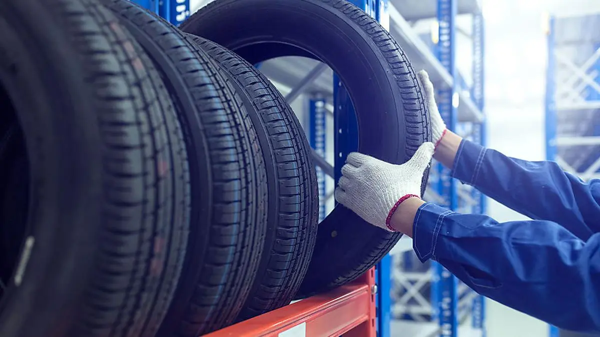 Large modern warehouse with forklifts and stack of car tires