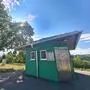 Ein grünes WC-Häuschen steht auf einem Parkplatz