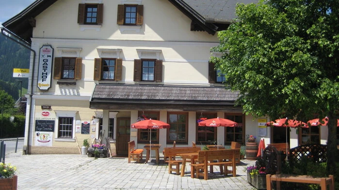 Ein Gasthof von außen bei Sonnenschein