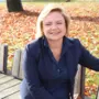 Eine blonde Frau sitzt auf einer Parkbank und lächelt in die Kamera. | Isabella Wieser eröffnet bald ein italienisches Lokal in Althofen