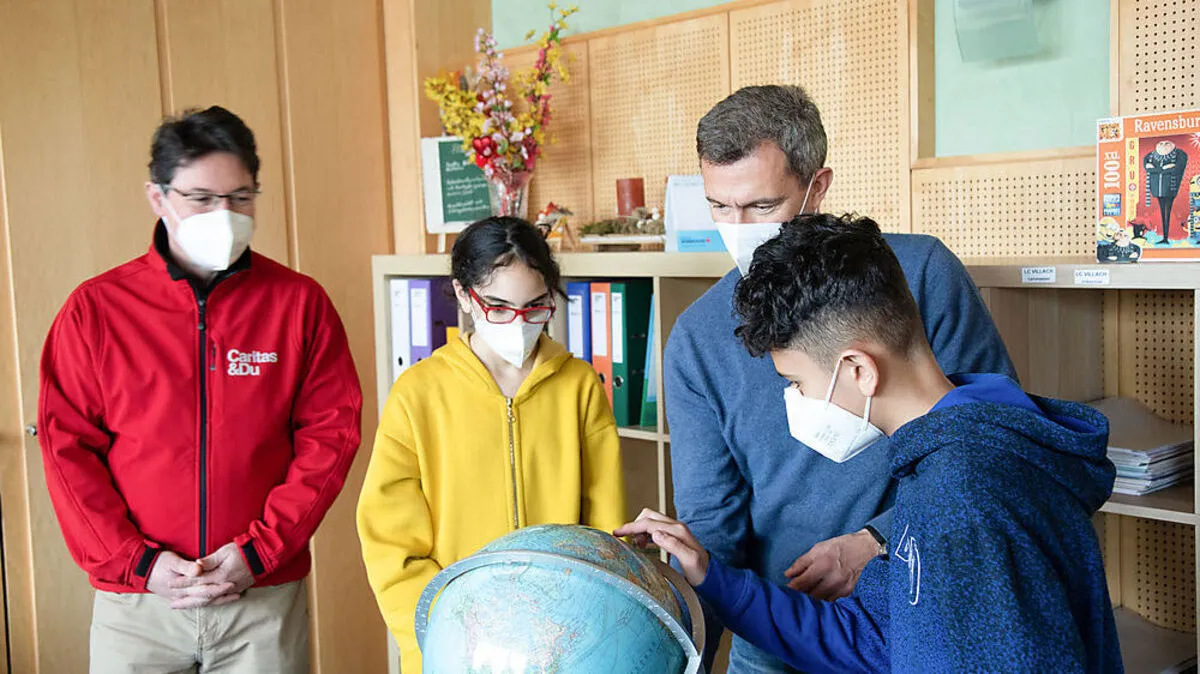 Daniela und Anas vom Lerncafé zeigen Norbert Marcher, dem Geschäftsführer der „Marcher Fleischwerke“, und Caritasdirektor Ernst Sandriesser ihre Herkunftsländer Armenien und Irak auf dem Globus