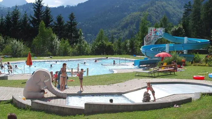 Ein Blick auf das Erlebnisfreibad mit der großen blauen Rutsche in Bad Eisenkappel