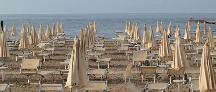Liegen und Sonnenschirme am Strand von Grado.