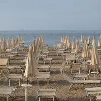 Liegen und Sonnenschirme am Strand von Grado.