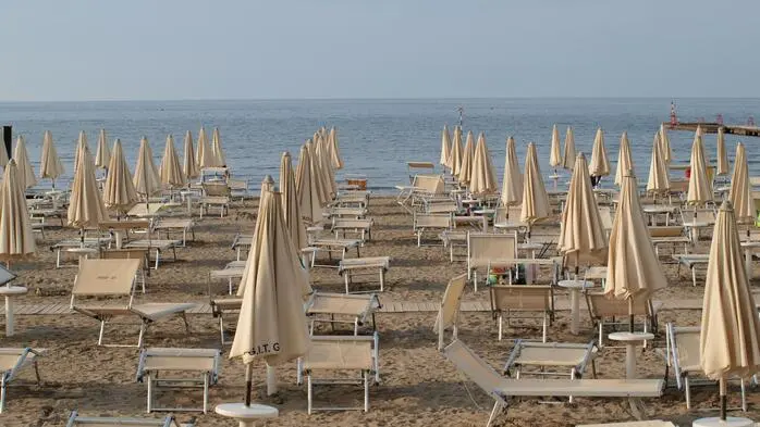 Liegen und Sonnenschirme am Strand von Grado.