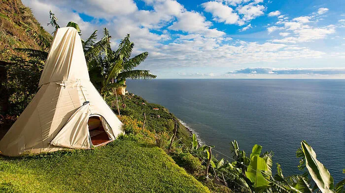 Madeira. 100 Meter über dem Strand von Anjos thronen auf dem Biobauernhof Canto das Fontes zwei Tipis in einemDschungel aus Bananenstauden.