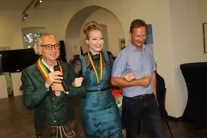 Was zu einer Trilogie noch fehlt wird durch die Handwerkskunst von Schneidermeisterin Johanna Böhm-Eberlein (Mitte) vervollständigt. Sie ist es, die dem unikaten Stoff die passende Form gibt, um beim Schnitt und der umgesetzten Nähkunst, einerseits dem edlen Wein und andererseits den Weinrittern, gerecht zu werden. Dabei werden Details in den Kleidungsstücken gezeigt, die unseren Gästen veranschaulicht, dass nähen mehr ist, als Stoffe mit Nadel und Faden zu verbinden. Sowohl die Damenroben von Böhm-Eberlein, als auch die angefertigten Herrensakkos von Anita Lechner-Gröss sind im Stoff und auch in der Farbe mit dem zur Verkostung angebotenen Wein abgestimmt. Eine, wie wir meinen Sinn-phonie, erzählt in der Geschichte vom edlen Wein zur noblen Couture! Seht es Euch an.