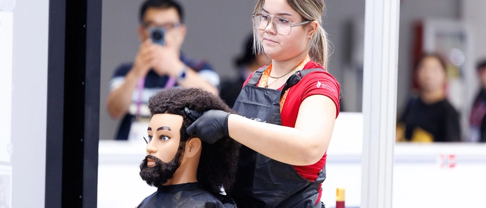 Friseurin Angelina Rainer frisiert einen Übungskopf