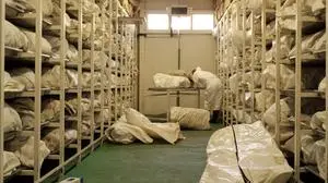 (FILES) A pathologist uncovers one of some 4000 body bags kept inside a giant refrigerator in Tuzla on July 1, 2004, the remains of the bodies of Muslim men and boys massacred in the eastern Bosnian town of Srebrenica in 1995. The UN General Assembly voted May 23, 2024, to establish an annual day of remembrance for the 1995 Srebrenica genocide, despite furious opposition from Bosnian Serbs and Serbia. The resolution written by Germany and Rwanda -- countries synonymous with genocide in the 20th century -- received 84 votes in favor, 19 against with 68 abstentions and makes July 11, "International Day of Remembrance of the Srebrenica Genocide." (Photo by AFP)