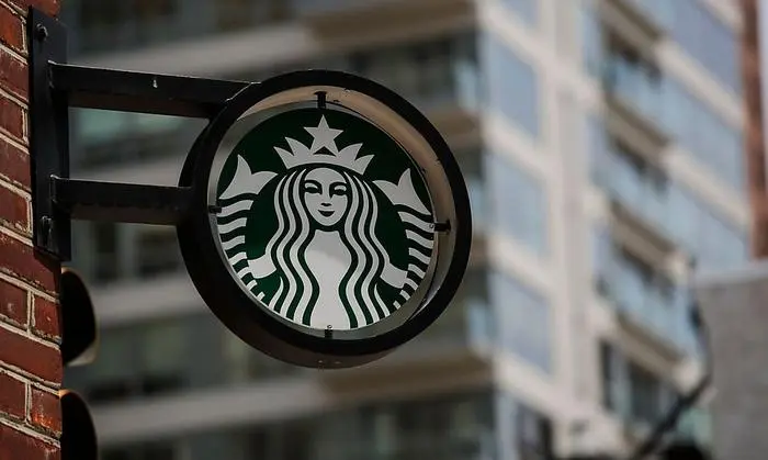 (FILES) In this file photo taken on May 29, 2018 the Starbucks logo is seen outside a store in Philadelphia. - Starbucks said June 28, 2020 that it will pause its advertising on social media while it studies ways to 