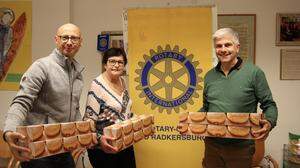 Christian Contola (l.) und Christian Korn (r.) vom Rotary Club Bad Radkersburg übergaben Anna Mir eine Krapfenspende