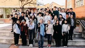 Das Foto zeigt Schülerinnen und Schüler, die ihre Handys in die Luft halten