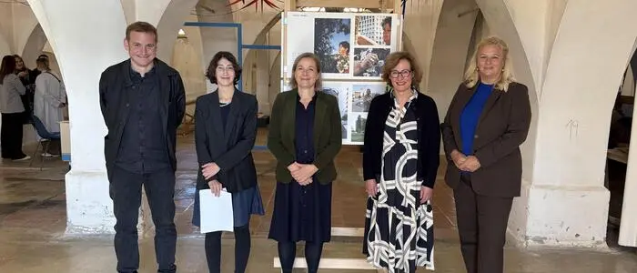 Fünf Personen stehen in der Ausstellung unter einem Gewölbebogen