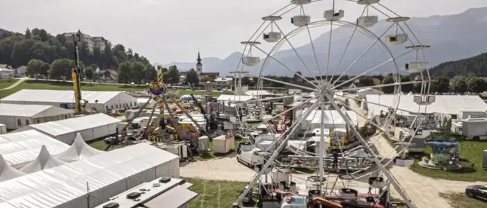 Zu sehen ist das Wiesenmarkt-Gelände in Bleiburg dort stehen bereits zahlreiche Zelte und Fahrgeräte 