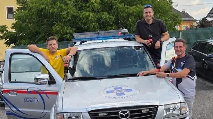 Das Einsatzfahrzeug und drei Mitglieder der Wasserrettung