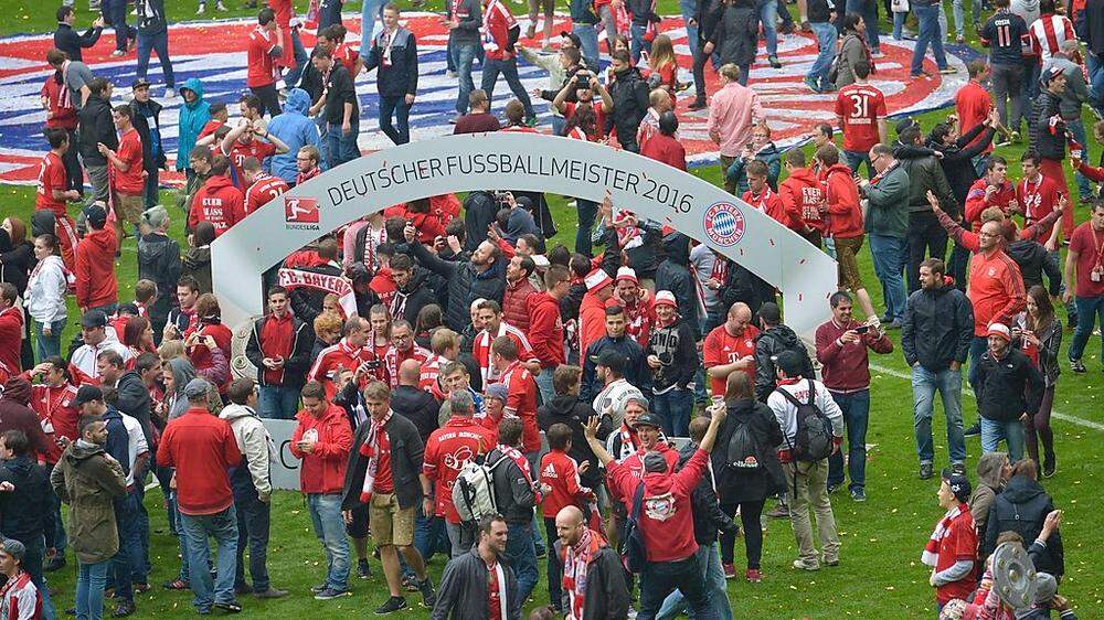 Um mit ihren Lieblingen feier zu können, stürmten die Bayern-Fans den Rasen der Allianz-Arena