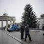 Police officers patrol around the Christmas Tree in front of the Brandenburg Gate the Pariser Platz in Berlin, Germany, Wednesday, Dec. 21, 2022. Climate activists have cut off the tip of the Christmas, tree erected in front of Berlin's iconic Brandenburg Gate. The group Last Generation said two of its members used a hydraulic lift and a hand saw to cut six feet off the top of the 50-foot tree.(AP Photo/Markus Schreiber)
