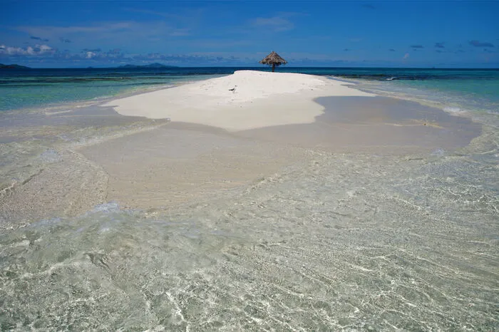 Sehr klein, sehr fein - zumindest der Sand: Die „Insel“ Mopion liegt in der Karibik und gehört zu St. Vincent und die Grenadinen. Das allein klingt schon wie eine Erfindung, aber das Beste kommt noch: Auf der Insel vulgo Sandbank steht nichts außer ein einzelner Sonnenschirm aus Palmwedeln. Ebbe und Flut bestimmen die Größe des Eilands. Vielleicht ist Mopion das perfekte Paradies: Sand, Meer und ein Sonnenschirm. Weniger gibt es auf dieser Welt, die den Überfluss zelebriert, vermutlich nirgendwo.