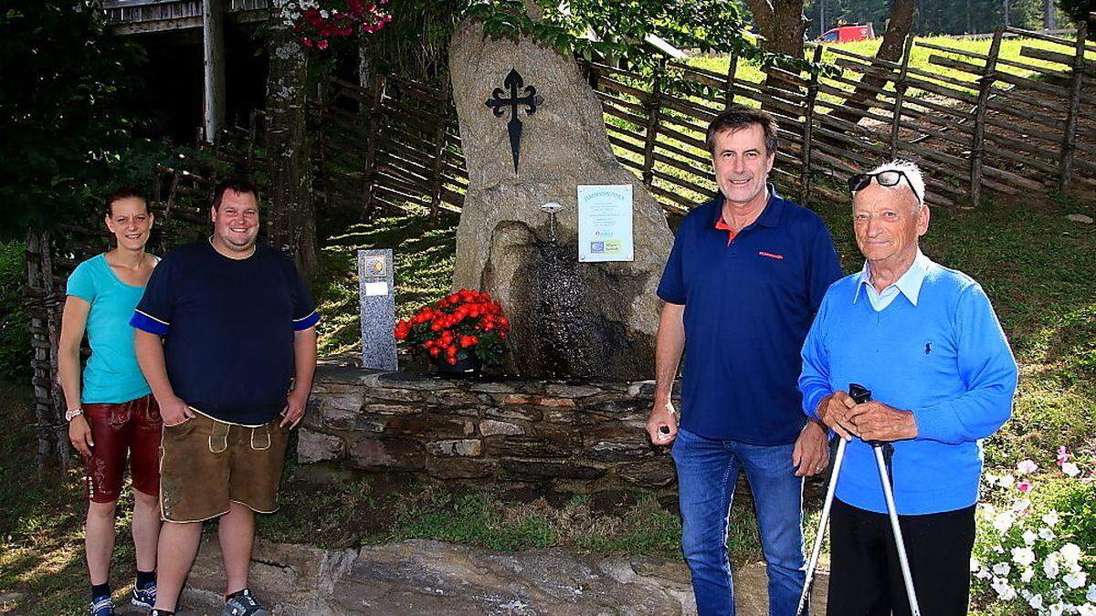 Wirtsleute Jasmin und Andreas Gruber, Reinhold Waldhaus und Seniorwirt Karl Gruber vor dem Jakobsbrunnen