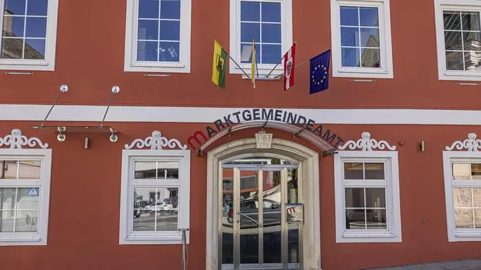 Ein rotes Gebäude mit dem Schriftzug „Gemeindeamt“