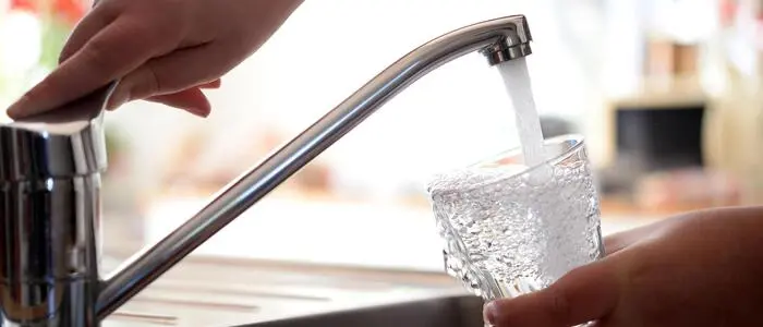 Eine Nahaufnahme eines Glases, das mit Wasser gefüllt wird.