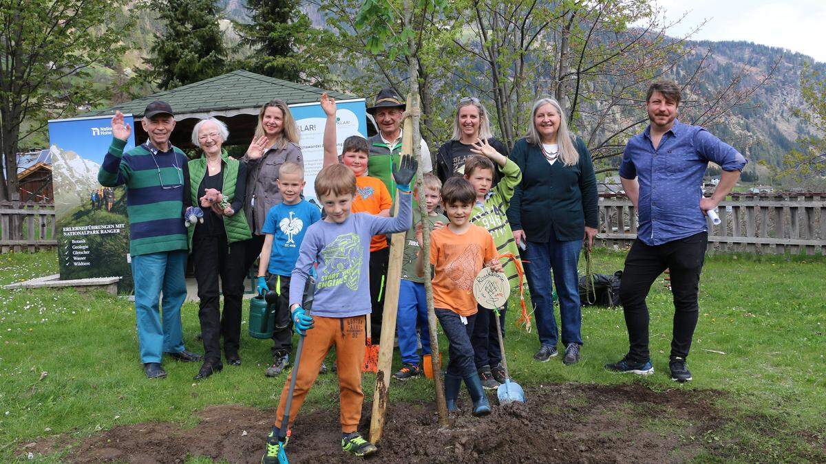 Maler Adi Holzer mit Ehefrau Kim, KLAR!-Managerin Sabine Seidler, Nationalparkranger Georg Granig, Klar!-Mitglieder Marika Göritzer und Melitta Fitzer sowie Bernhard Bergmann (Lanz Naturspiele) beim Baumpflanzen mit den Winklerner Volksschülern