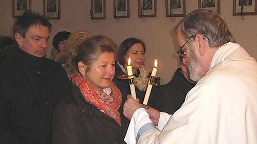 Beim Blasiussegen hält der Priester – wie hier Nepomuk Wornik in Tschrietes – gekreuzte Kerzen vor die Gläubigen