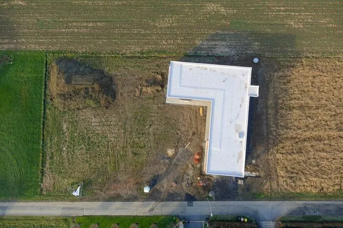 Eine Luftaufnahme aus der Bauzeit: Der Bau liegt leicht gedreht im Grundstück.